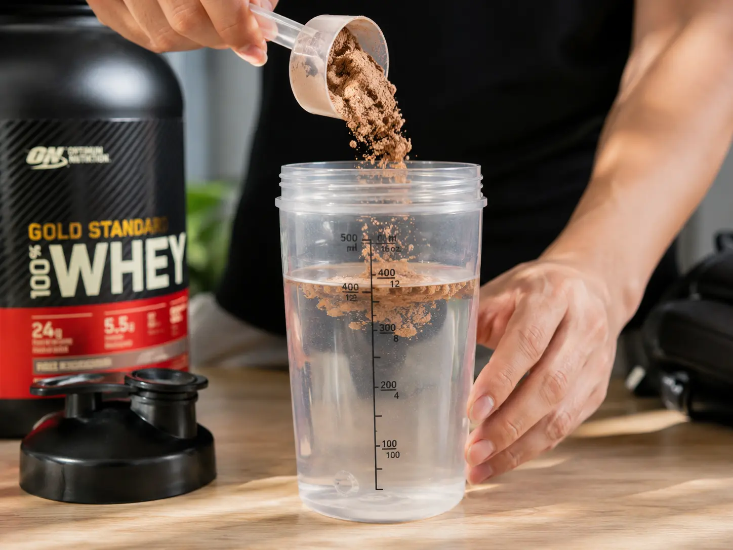 Người đang pha whey protein vào bình lắc